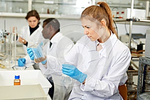 Young woman scientist working in research laboratory performing experiments