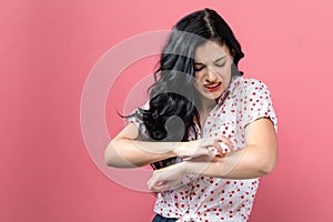 Young woman scratching her itchy arm. photo