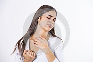 Young woman scratching her neck due to itching on a gray background. Female has an itching neck. The concept of allergy symptoms