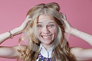 Young woman screaming from pain and holding her head with selective focus