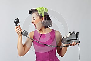 Young woman screaming into a phone .