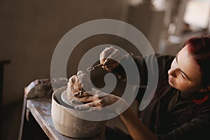 Young woman sculptor artist creating a bust sculpture