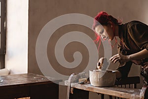 Young woman sculptor artist creating a bust sculpture