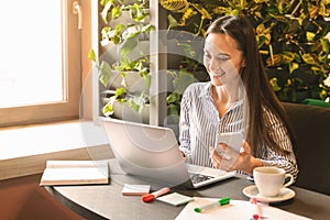 Young woman searching information in internet via laptop