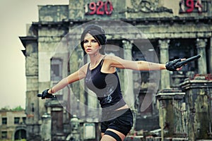 Young woman is a secret agent with a gun in a ruined city.