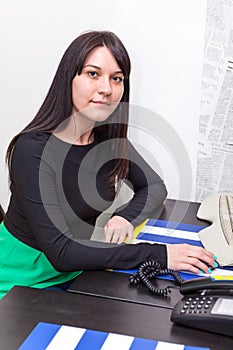 Young woman secretary sitting at table with computer mouse