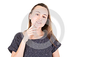 Young woman seductively holding finger to chin on white background