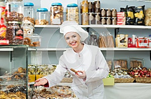 Young woman seller offering sweets