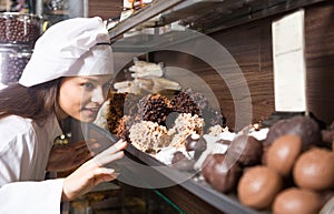 Young woman selling fine chocolates and confectionery in cafe