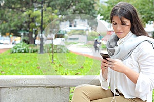 Young woman sending message with smartphone.