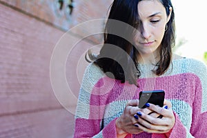 Young woman sending message with smartphone.