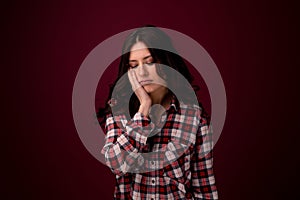 Young woman with sensitive teeth and cold ice cream on color background