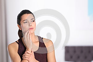 Young woman with sensitive teeth indoors.