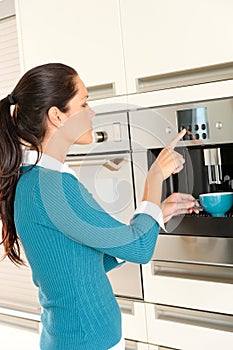 Young woman setting coffee maker machine kitchen