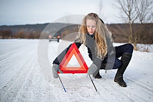 Young woman setting up a warning triangle