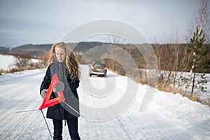 Young woman setting up a warning triangle