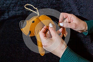 Young woman sews hand made christmas decoration