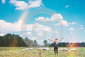 Young woman with sheeps in the meadow