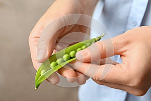 Young woman shelling green peas, closeup