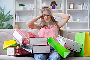 The young woman with shopping bags indoors home on sofa