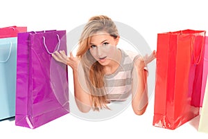 Young woman with shopping bags lying on floor