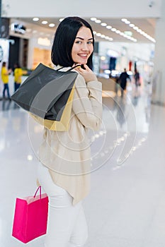 Young woman with shopping bags on mall background. Happy and joyful