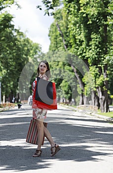 Young Woman with Shopping Bags Outdoors in a Park