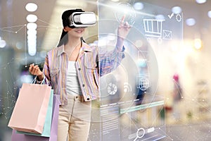 Young woman with shopping bags using virtual reality headset in simulated store