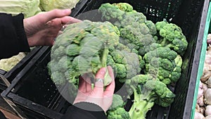 Young woman shopping broccoli in supermarket. Slowmotion.