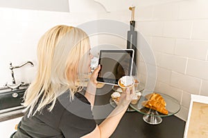 Young woman shopping fresh food online using a digital tablet at home. Concept of buying online using tablet