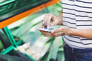 Young woman shopping healthy food in supermarket blur background. Female hands buy products and using mobile smart phone in store