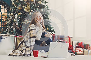 Young woman shopping online in cozy christmas interior