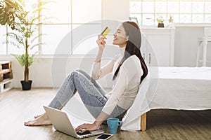 Young Woman shopping online with  credit card and  laptop at home