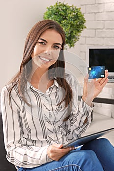 Young woman shopping online with credit card and tablet PC at home