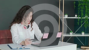 Young woman shopping online with credit card using computer at home.