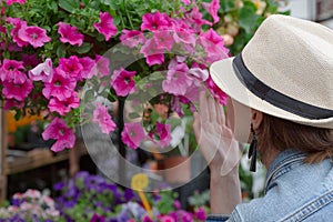 Young woman shopping in an outdoors fresh urban flowers market, buying and picking from a large variety of colorful floral