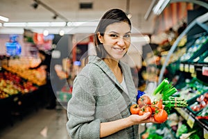 Young woman shopping in the supermarket grocery store.Buying organic vegetables sustainable produce.Natural source of vitamins and