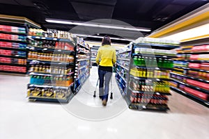 Young woman shopping in the supermarket ,motion blur