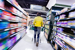 Young woman shopping in the supermarket,motion blur