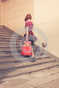 Young woman with shopping walking up stairs