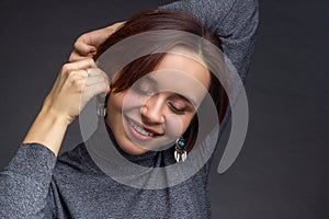 Young woman with short brown hair, in grey sweater