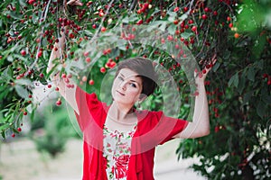 Young woman with short hair-cut standing near cherry tree