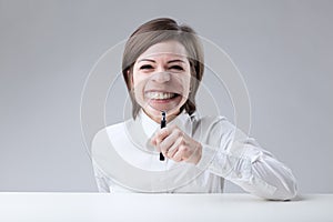 Young woman with short hair on a neutral background makes a funn