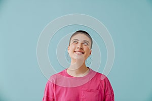 Young woman with short haircut smiling and looking upward