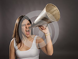 Young woman shouting with an old megaphone