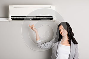 Young woman showing air conditioner