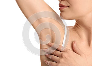 Young woman showing armpit with smooth clean skin on white background, closeup