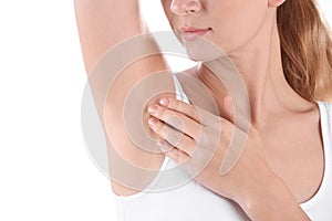 Young woman showing armpit on white background