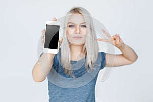 Young woman showing blank smartphone screen