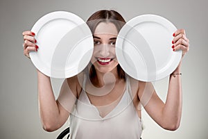 Young woman showing empty plates.